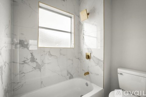 A bathroom with a marble wall and a tub.