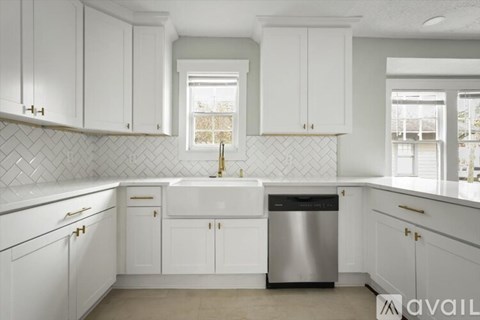 A kitchen with white cabinets and a stainless steel dishwasher.
