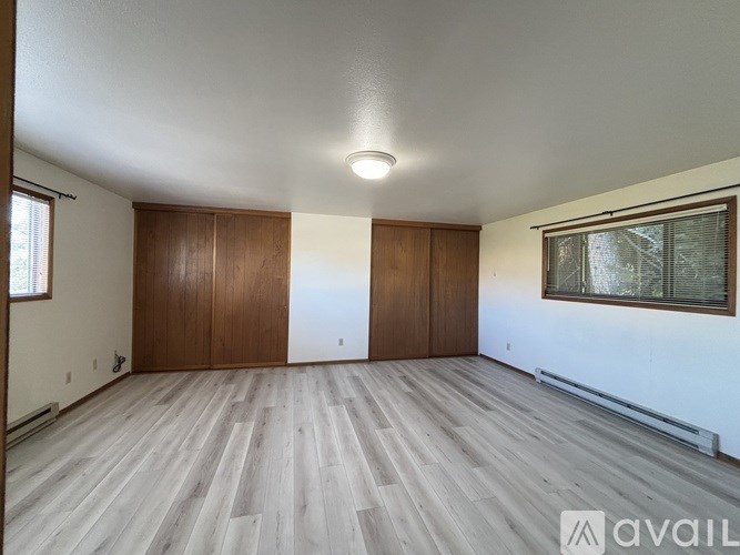 A room with wooden floors and two doors.