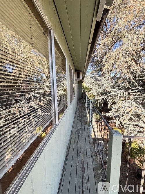A balcony with a metal railing and a view of trees.