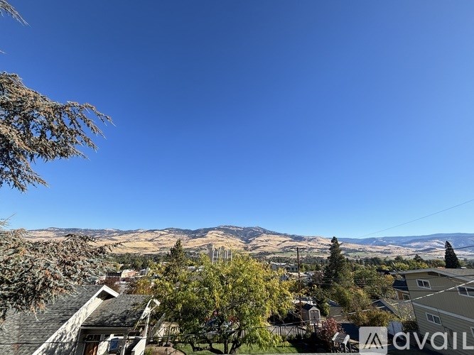 A view of a residential area with houses and trees under a clear blue sky.