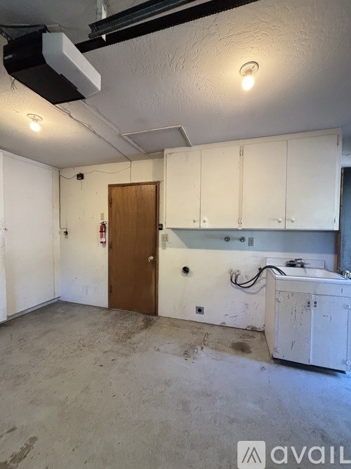 A room with a brown door and white cabinets.