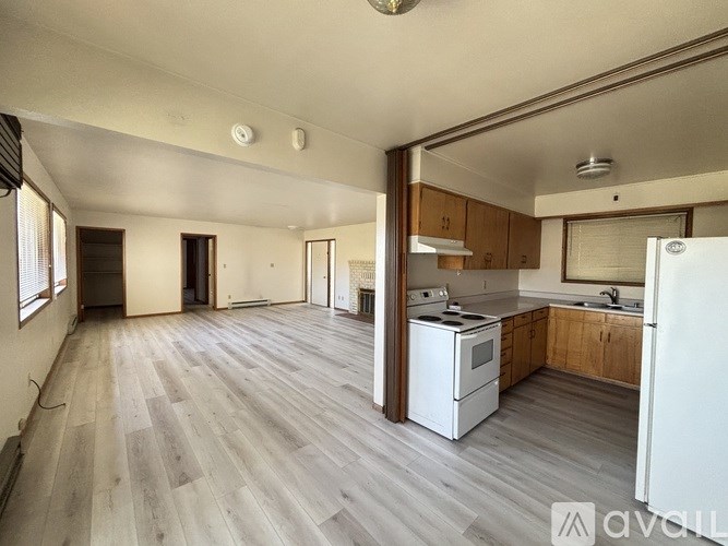 A spacious kitchen with wooden cabinets and a white refrigerator.