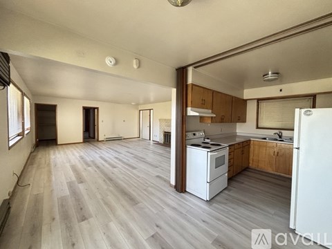 A spacious kitchen with wooden cabinets and a white refrigerator.