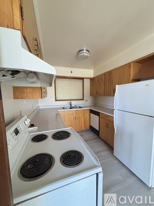 A kitchen with a white stove and refrigerator.