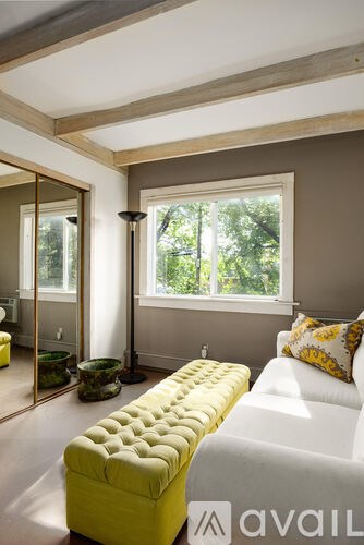 A bright room with a yellow bench and a white couch.