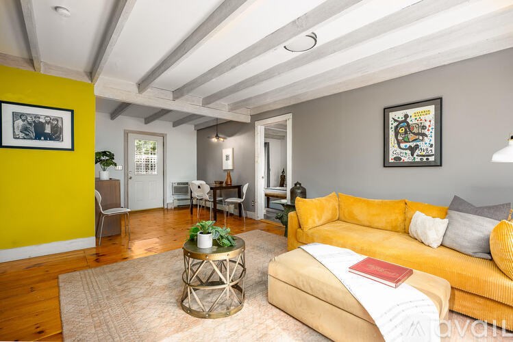 A living room with a yellow couch and a coffee table.