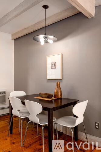 A modern dining room with a wooden table and white chairs.
