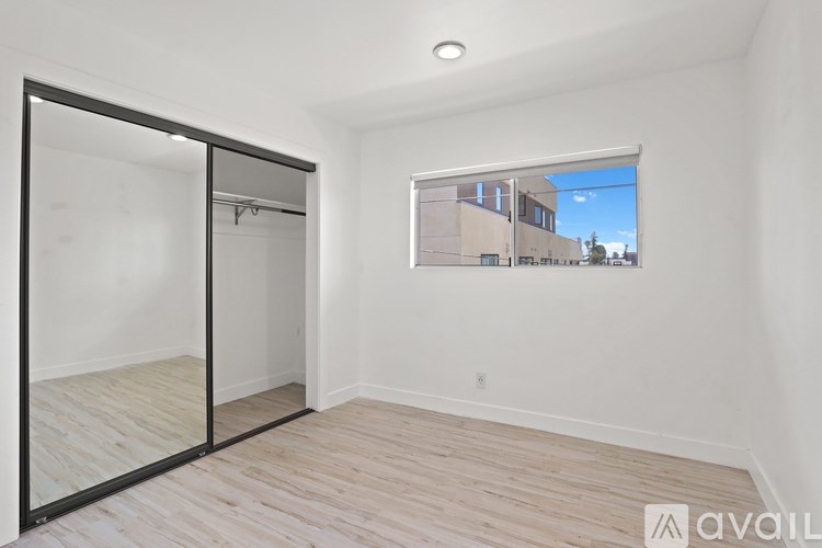 A room with a sliding glass door and wooden flooring.