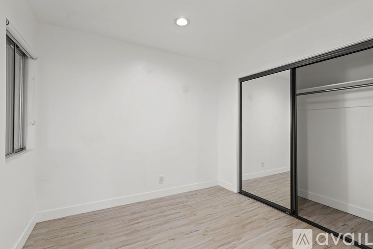 A room with a wooden floor and a sliding glass door.