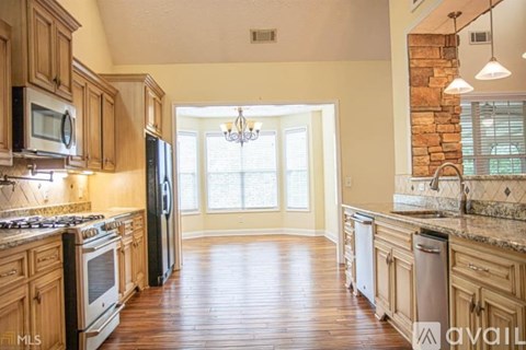 A kitchen with wooden cabinets and a stone wall.