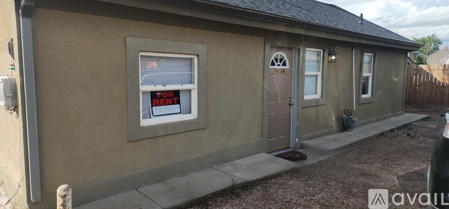 A small house with a "For Rent" sign in the window.