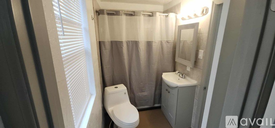 A small bathroom with a toilet, sink and shower curtain.