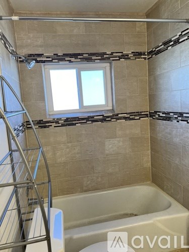 A bathroom with a tub and a window.