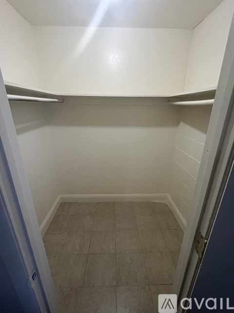 A small, empty room with a tiled floor and white walls.