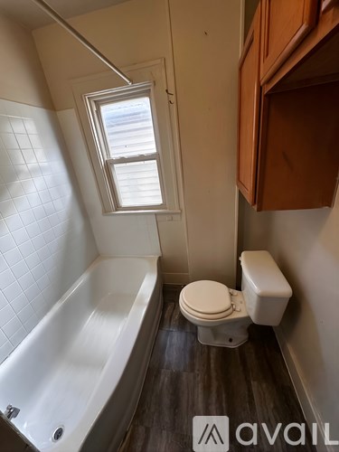 A white toilet sits next to a bathtub in a bathroom.