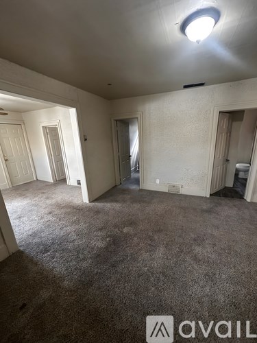 A room with a carpeted floor and a light on the ceiling.