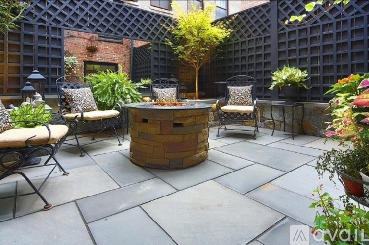 A patio with a table, chairs, and a tree.