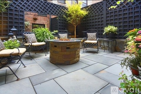 A patio with a table, chairs, and a tree.