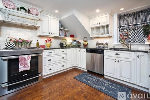 A kitchen with white cabinets and a black stove top.