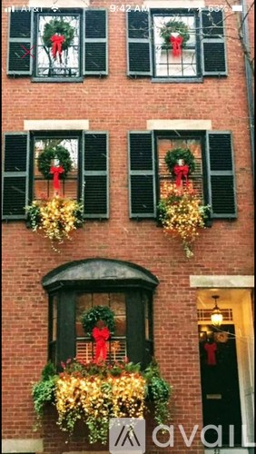 A building with green shutters and Christmas decorations.