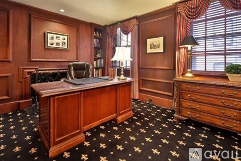 A room with a wooden desk and a black and white patterned carpet.
