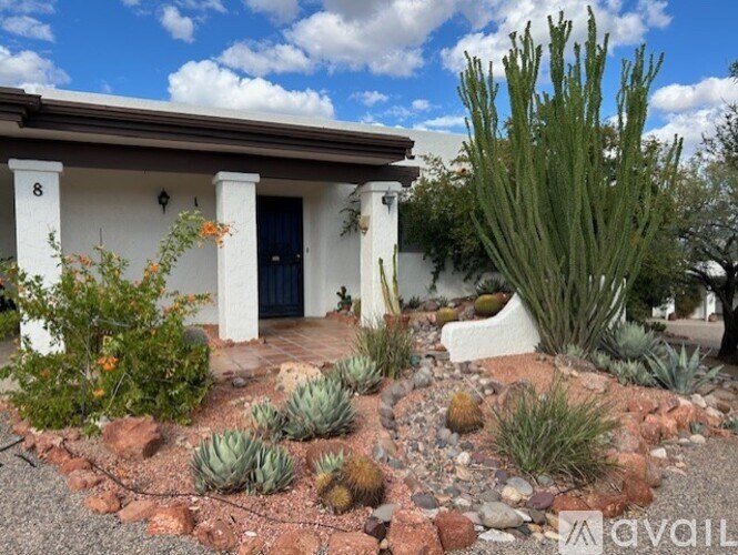 A white house with a blue door and a garden in front.