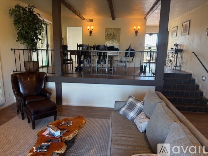 A living room with a couch, chair, and dining area.