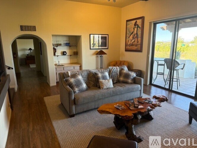 A living room with a couch, coffee table, and a painting on the wall.