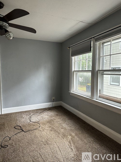 A room with a ceiling fan and a window.