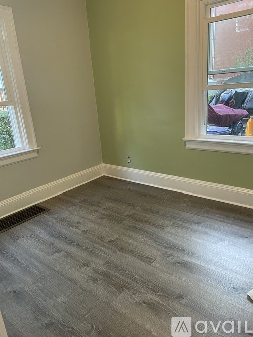 A room with a window and a grey floor.