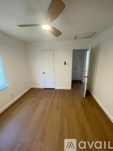 A room with wooden flooring and a ceiling fan.
