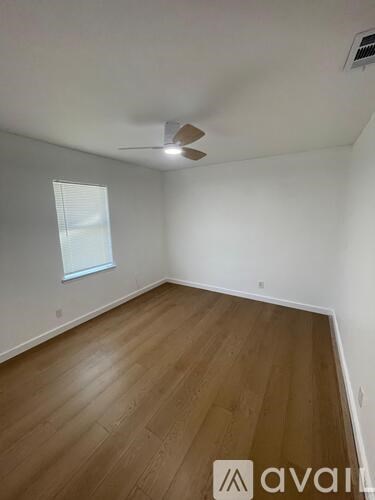 A room with wooden flooring and a ceiling fan.