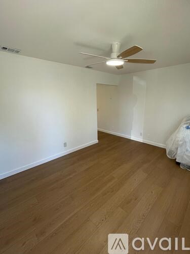 A room with wooden flooring and a ceiling fan.