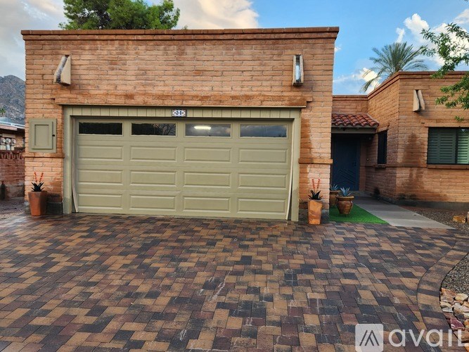 A brick house with a garage door and a driveway.