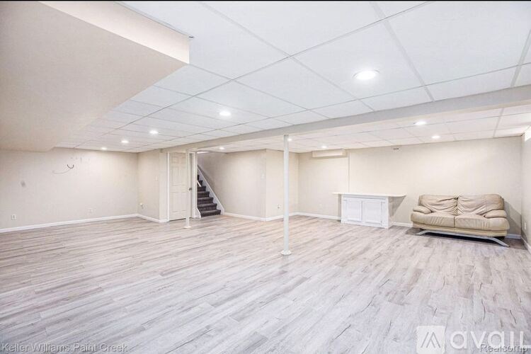 A spacious room with a staircase leading to another room.