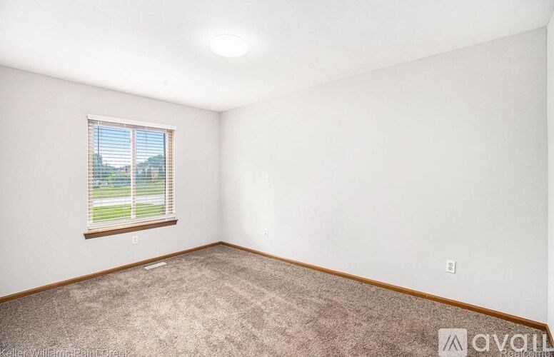 A room with a window and carpeted floor.