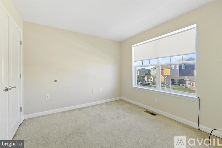 A room with a carpet floor, a window, and a door.