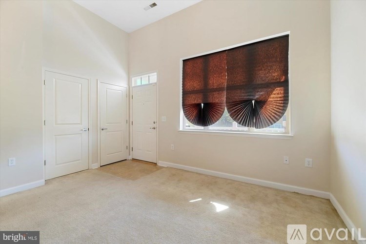 A room with a large window and a fan on the wall.
