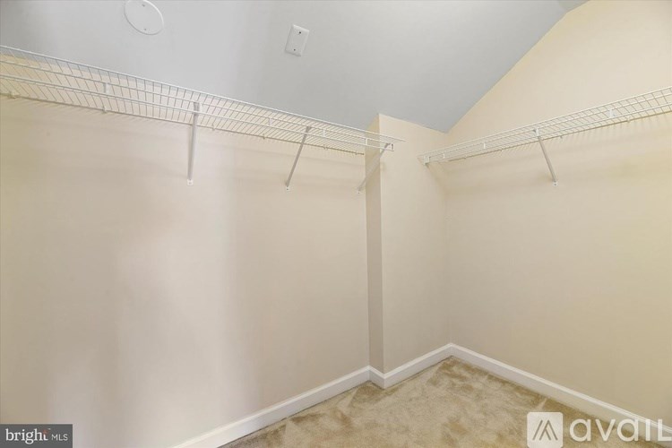 A room with a white ceiling and a wall with a shelf.