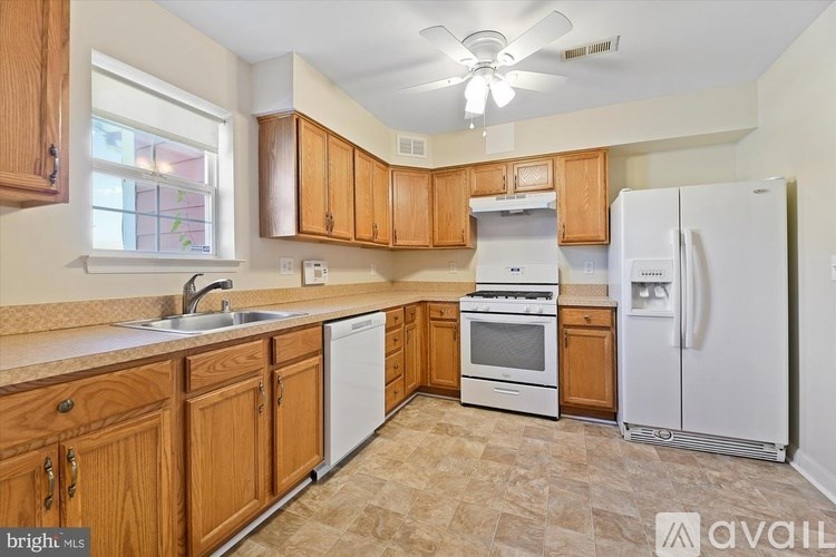A kitchen with wooden cabinets and a white refrigerator.