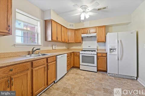 A kitchen with wooden cabinets and a white refrigerator.