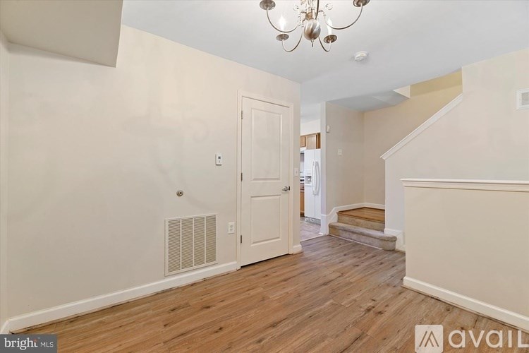 A room with a chandelier, a door, and a window.