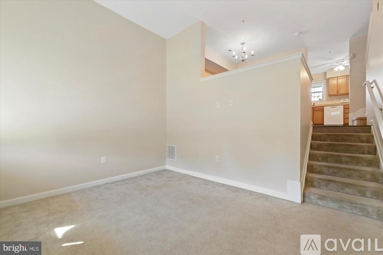 A spacious living room with a staircase leading to the upper floor.
