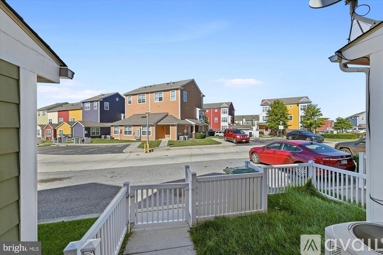 A row of houses with cars parked in front.