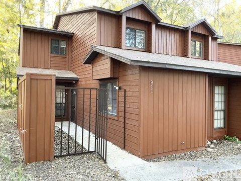 A brown house with a black gate in front.