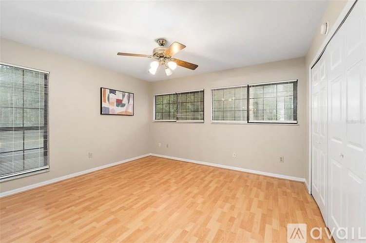 A room with a ceiling fan and wooden flooring.