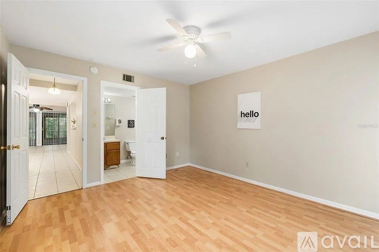 A room with wooden flooring and a ceiling fan.