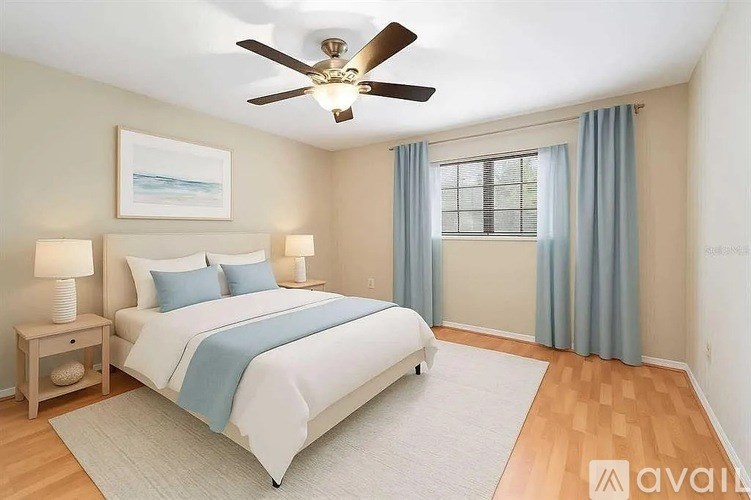 A bedroom with a large bed and a ceiling fan.