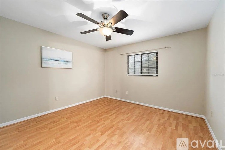 A room with a ceiling fan and a window with blinds.